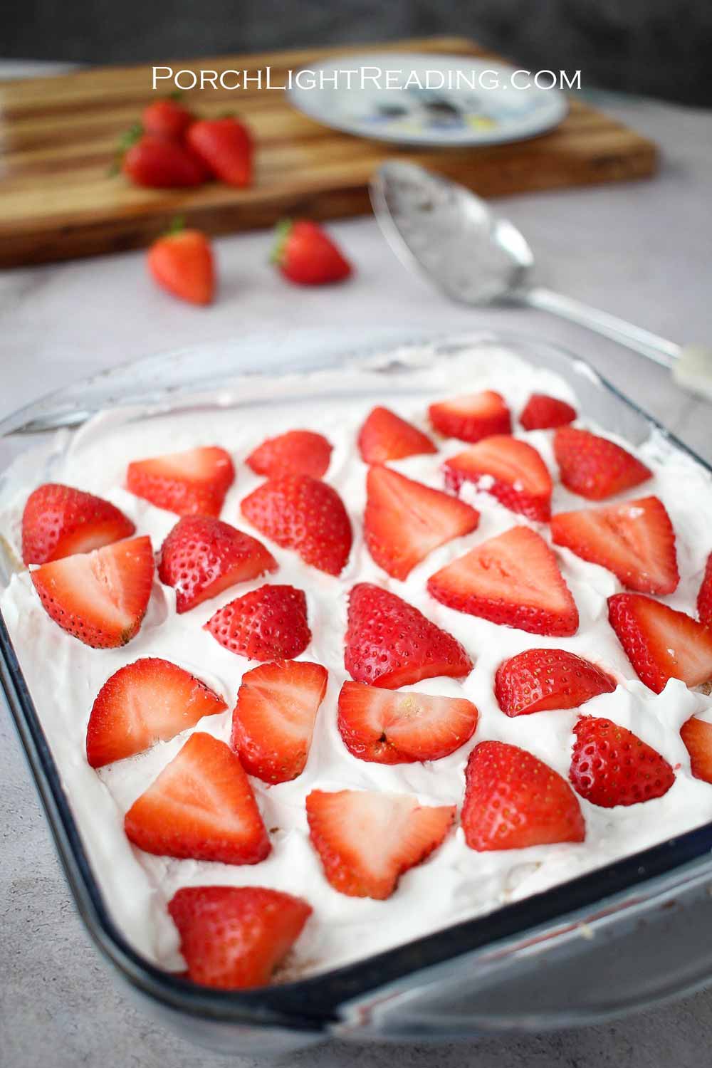 Strawberry icebox cake in an 8x8 baking dish with fresh, sliced, strawberries.
