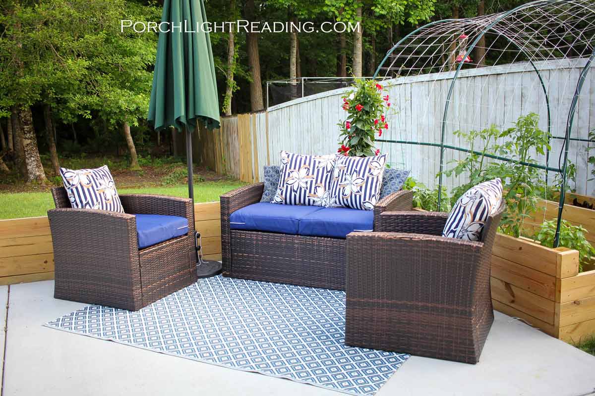 Used patio furniture with new DIY patio cushions against a small garden. 