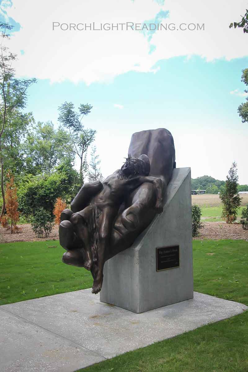 Sculpture of the crucified Christ in the hand of God.