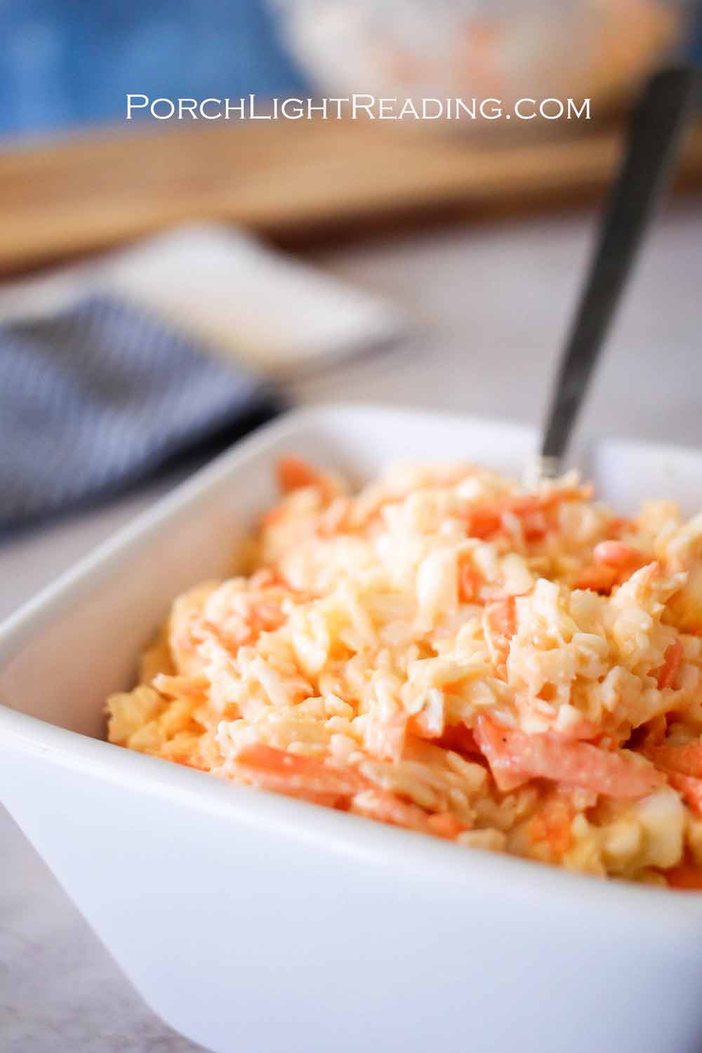 Homemade creamy slaw in a white serving dish.