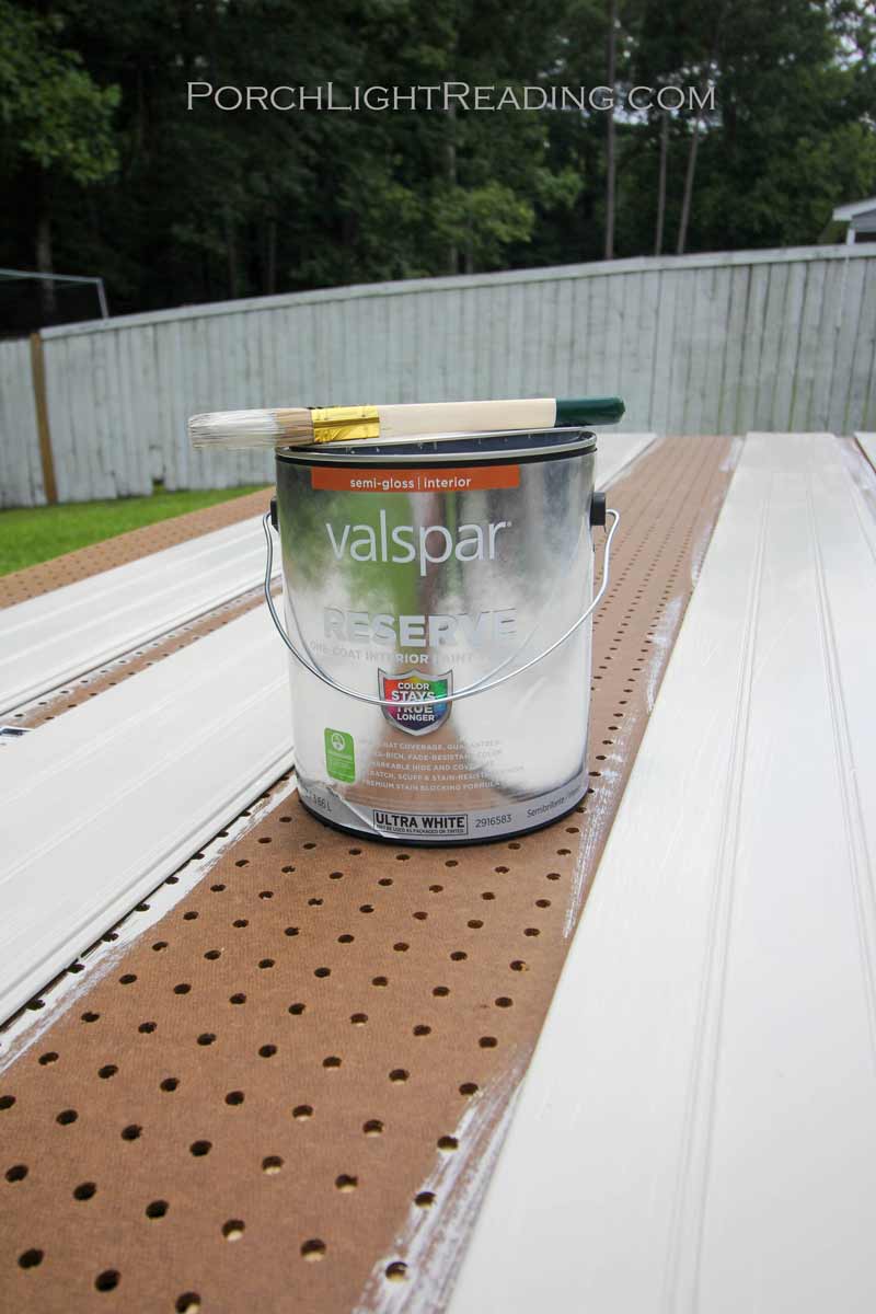 Painting eat beadboard plank a light gray color.