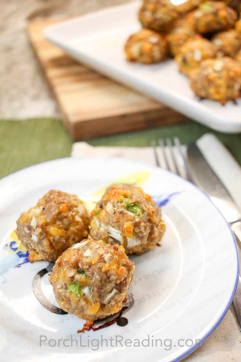 Three sausage balls on a blue and white plate. 