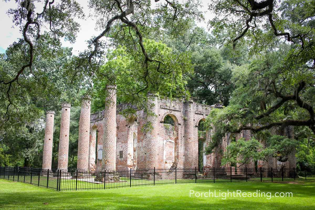 View of the Old Sheldon Church Ruins with four tall round columns and greenery surrounding.