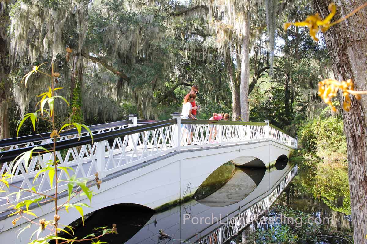 Family walking along the white bridge at Magnolia Gardens. 