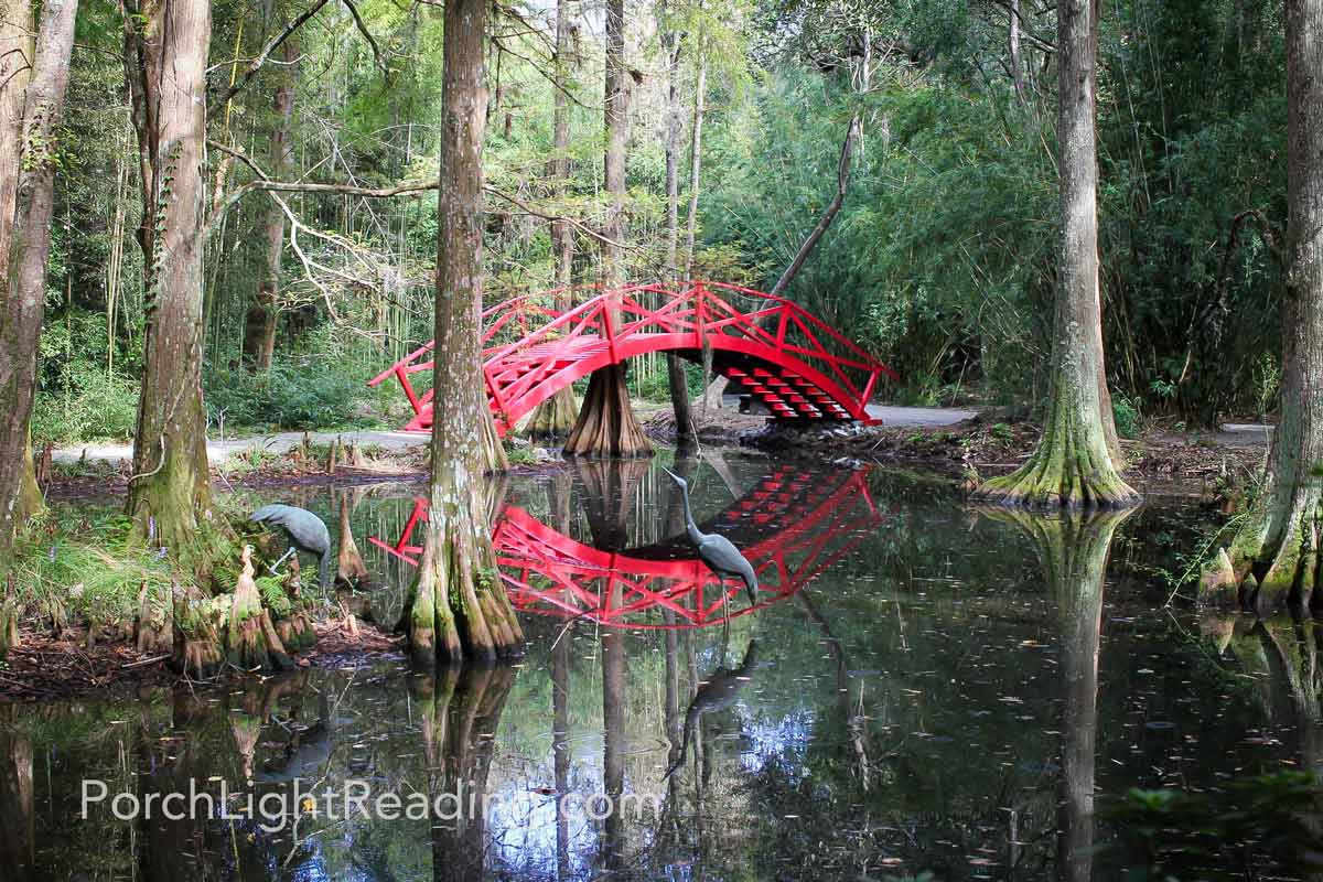 Red bridge reflecting in swamp waters.