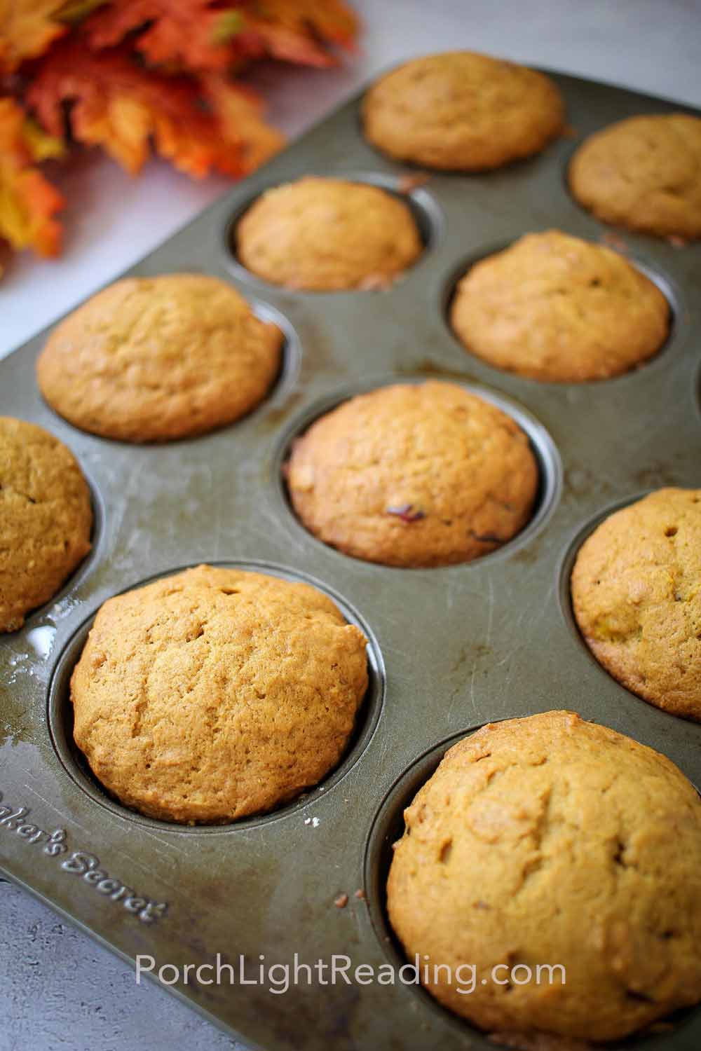 Golden pumpkin muffins straight out of the oven in the muffin tin.