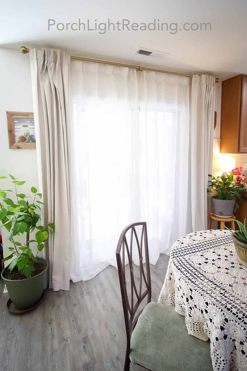 Cozy white curtains in front of a sliding glass door. 