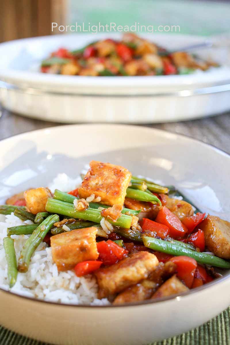 Tofu stir fry served for dinner in a bowl with rice and vegetables.