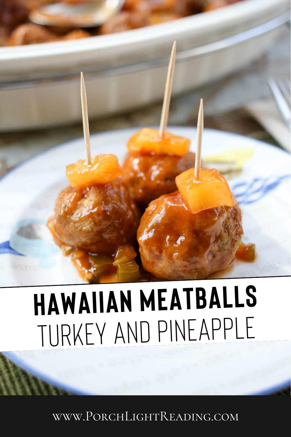 Hawaiian meatballs made with ground turkey. Served on a dinner plate with a toothpick and pineapple. 