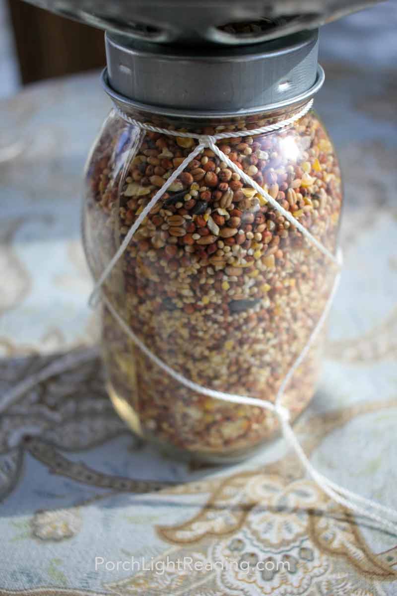 Twine with diamond pattern knots on mason jar filled with birdseed. 
