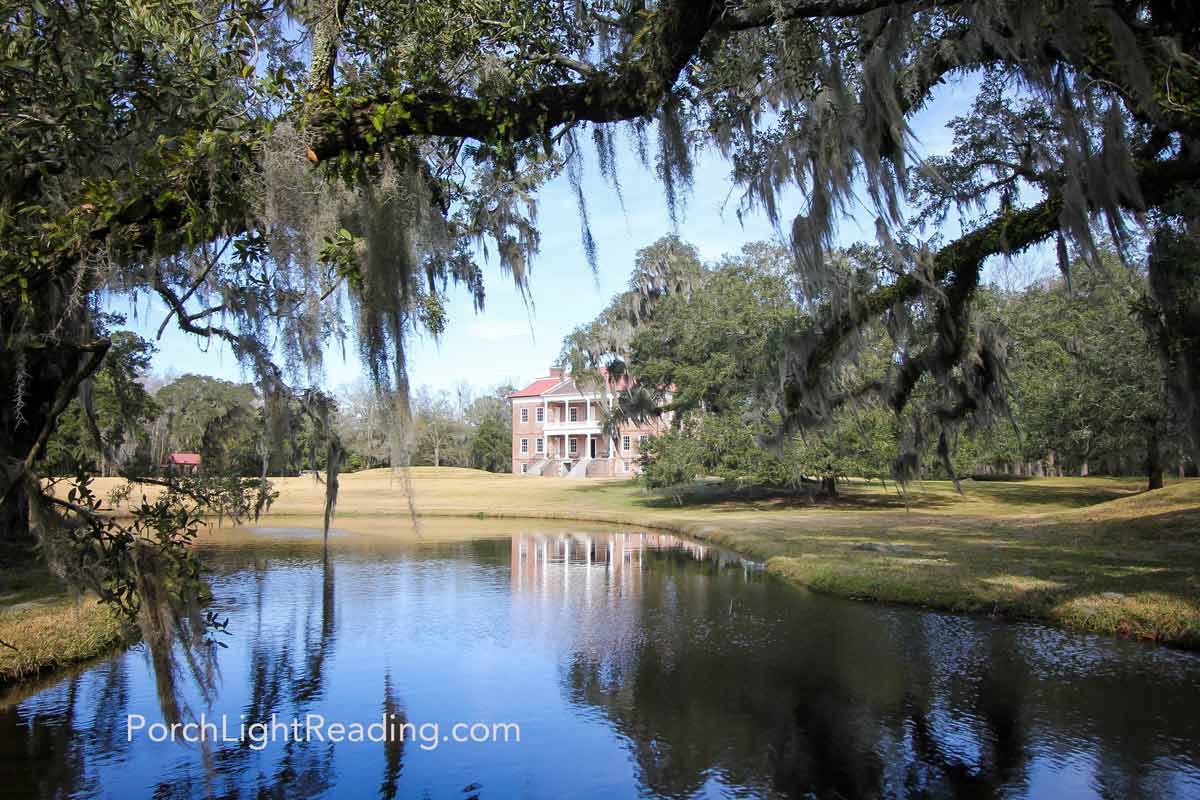 Lawn and moss covered trees hanging over the pond at Drayton Hall.