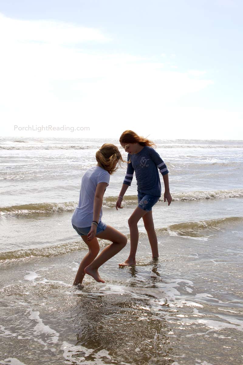 The kids playing in the ocean water.