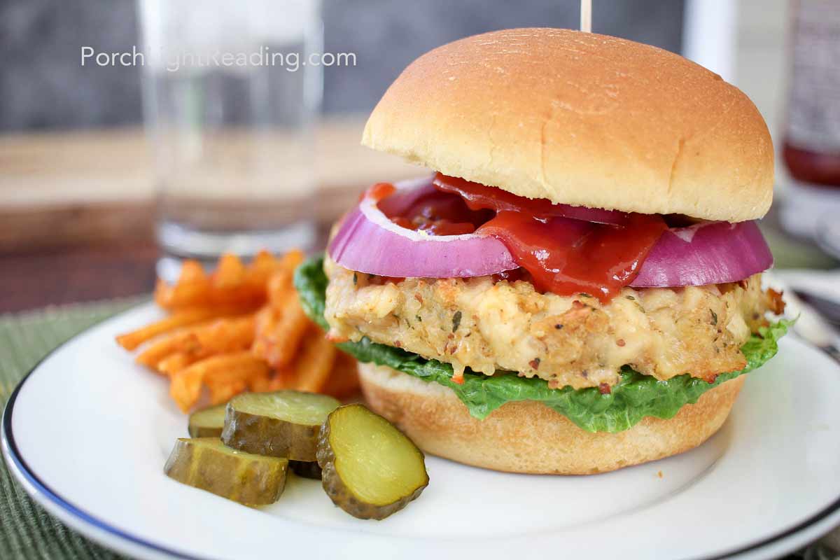 Chicken patties served on a bun with lettuce, tomato, red onion, and pickles. 