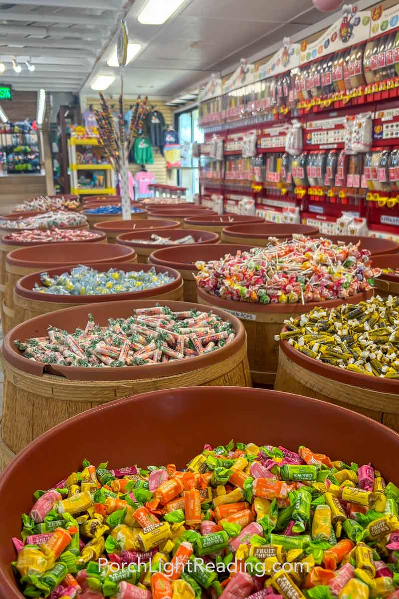 Candy in barrels with a wall of jelly beans. 
