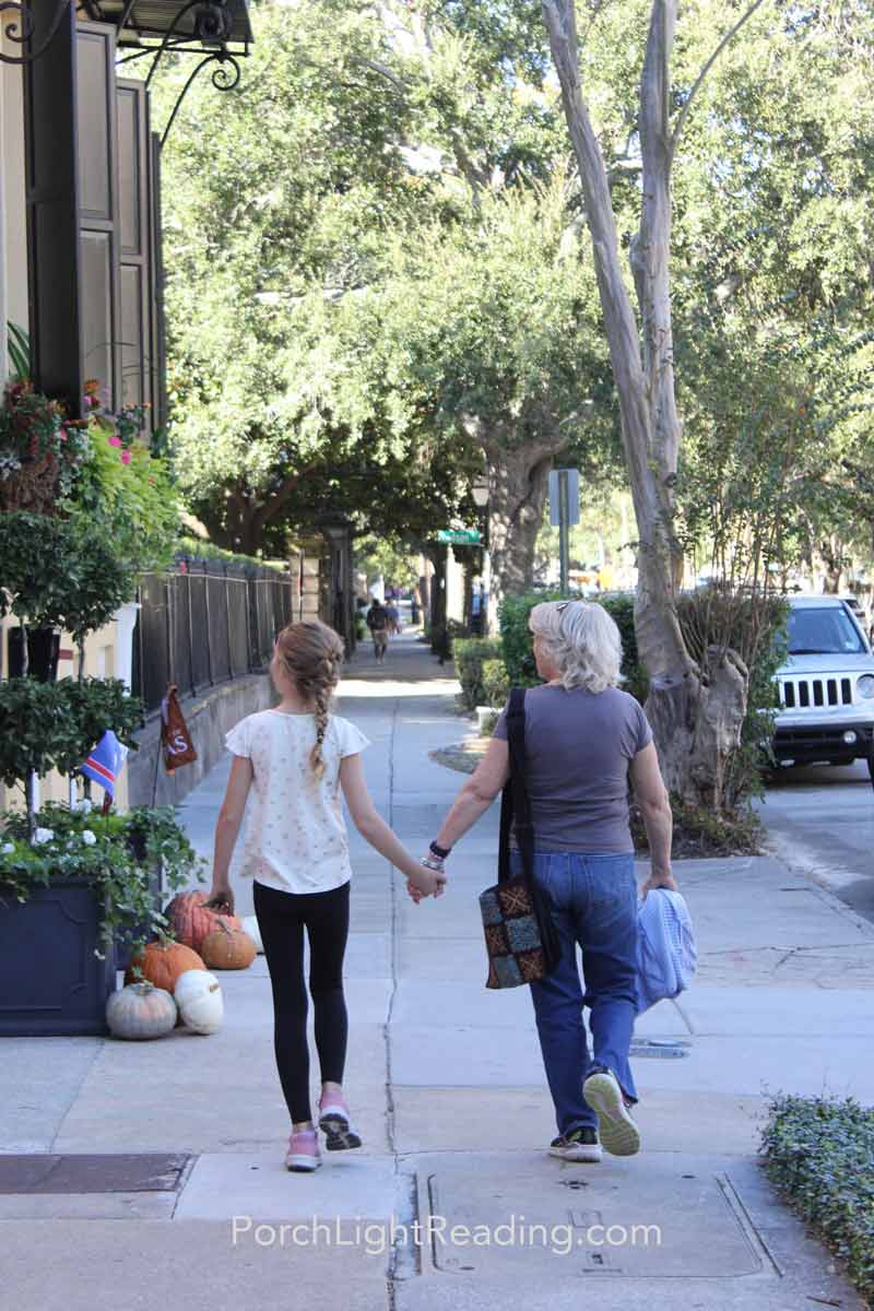 Grandmother and little girl holding hands while enjoying the historic houses. 