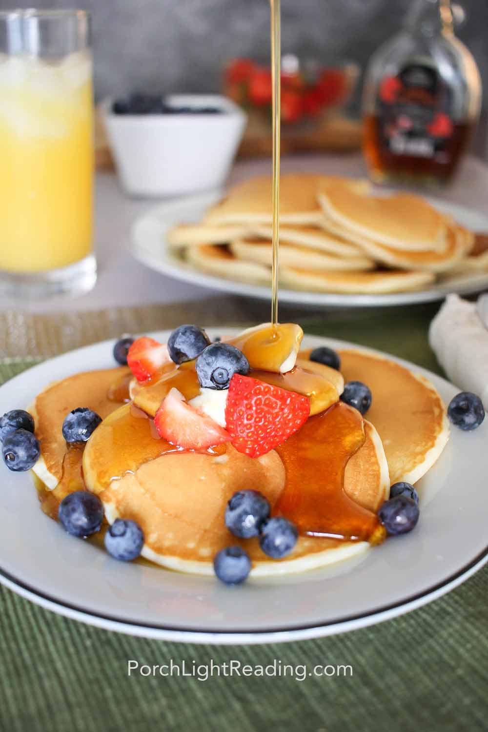 Fluffy cream cheese pancakes topped with fresh fruit and maple syrup. 