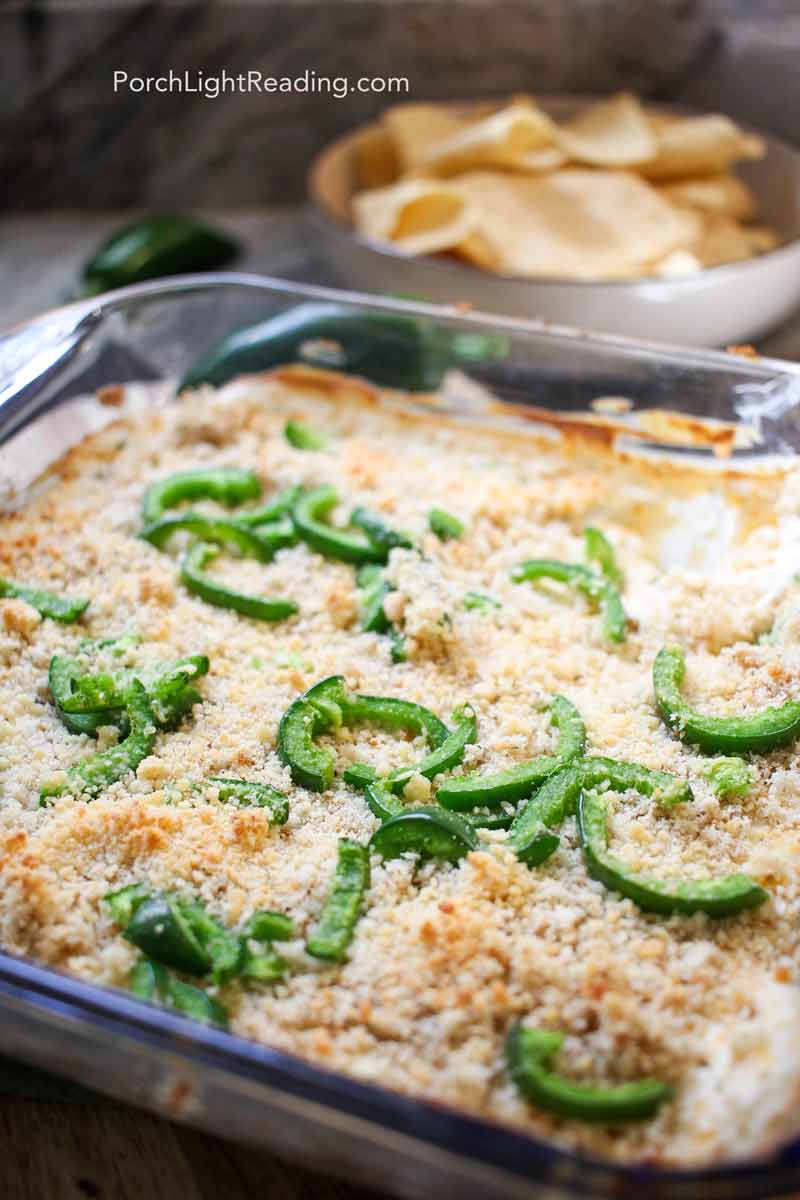 Golden baked jalapeno popper dip in a baking dish. Topped with panko breadcrumbs and jalpenos. 