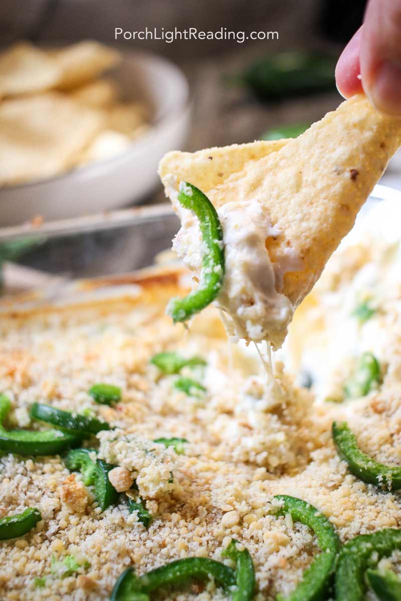 Close up of creamy cheese dip with chopped jalapenos on top. 