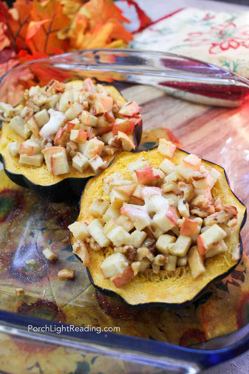 Apple stuffed acorn squash halved baked with brown sugar and walnuts. 