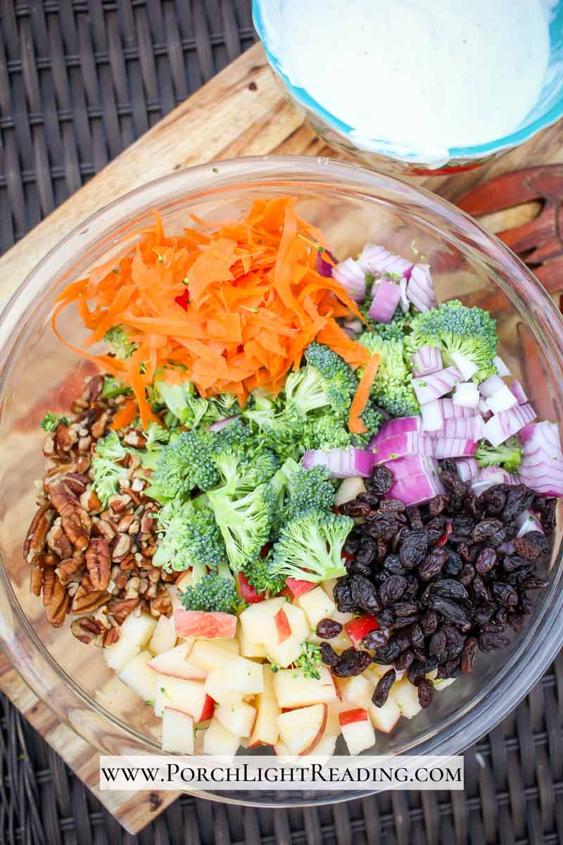 Broccoli salad ingredients with a side dish of yogurt dressing. 