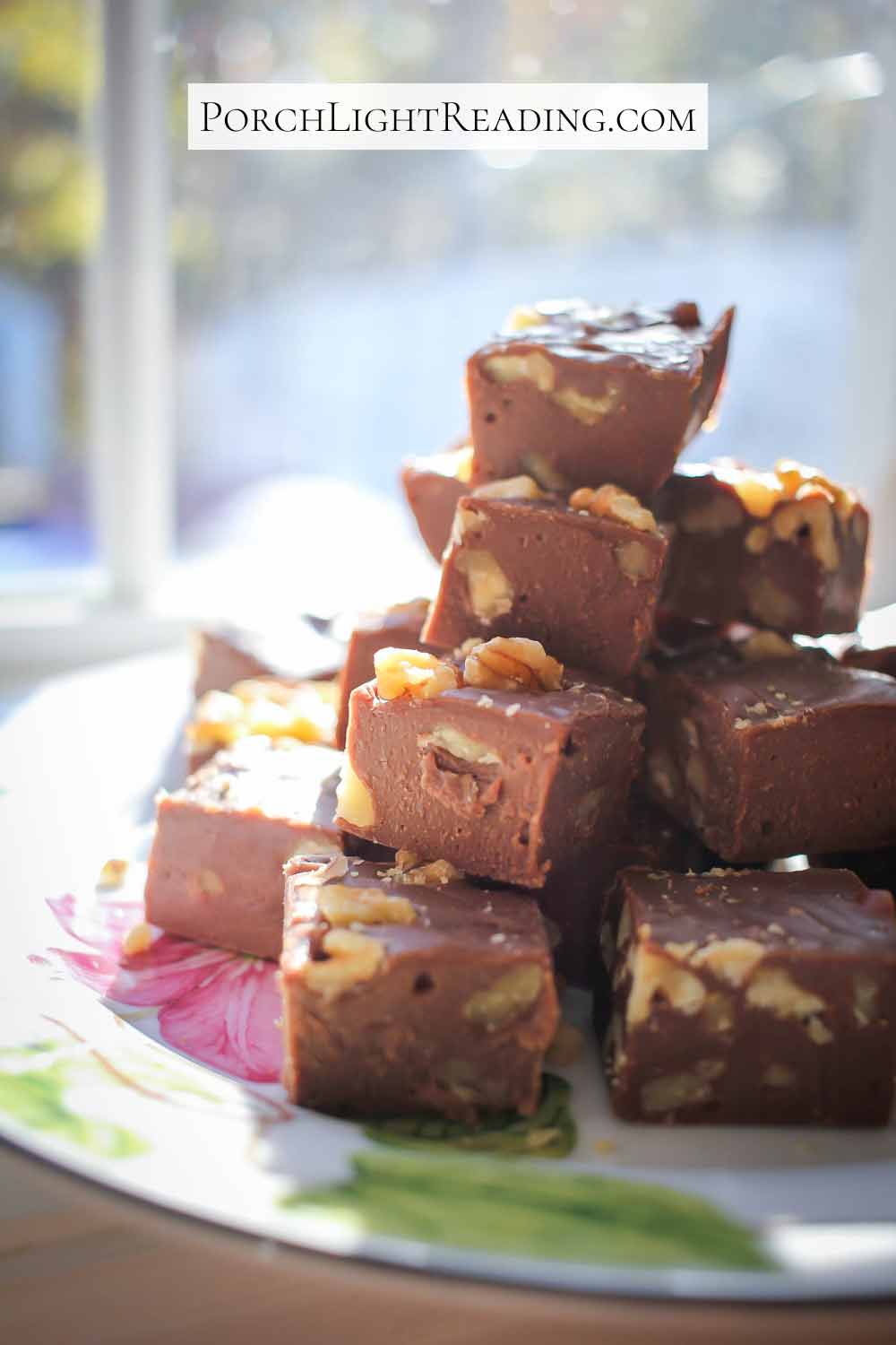 Homemade chocolate fudge with walnuts on a flower plate. 