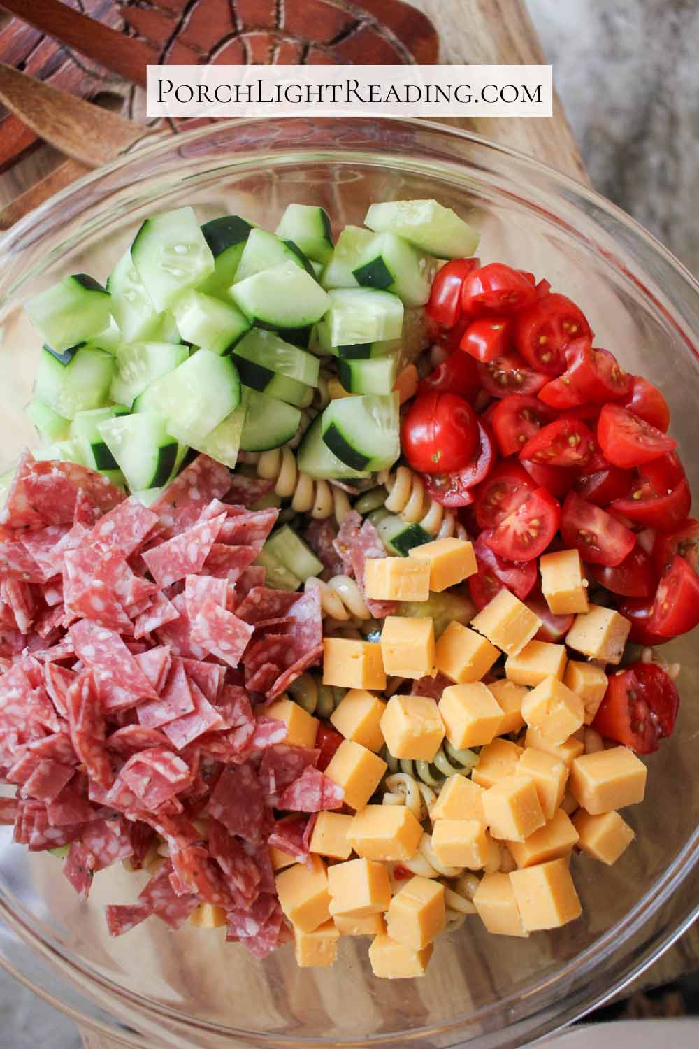 Homemade pasta salad with cucumbers, cherry tomatoes, cheese, and salami. 