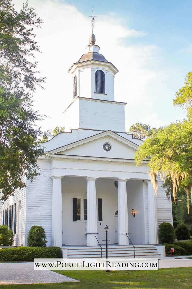 Large church with four tall columns and steeple. 