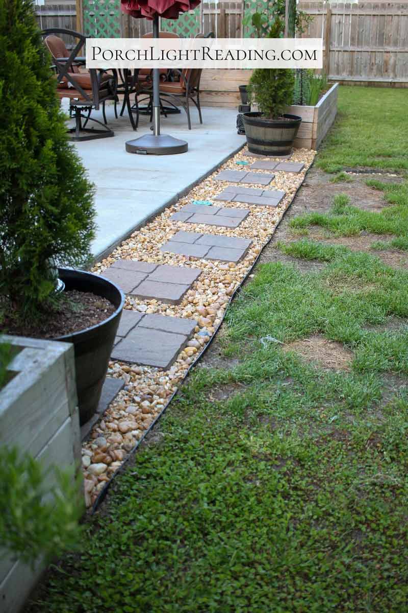 Nine pavers and pond pebbles between two raised garden beds. 
