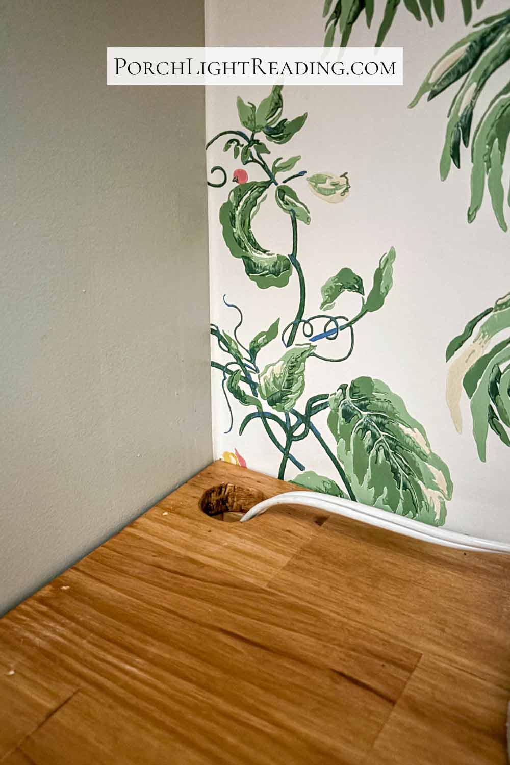 Small hole in the wooden shelve for appliance cords. 