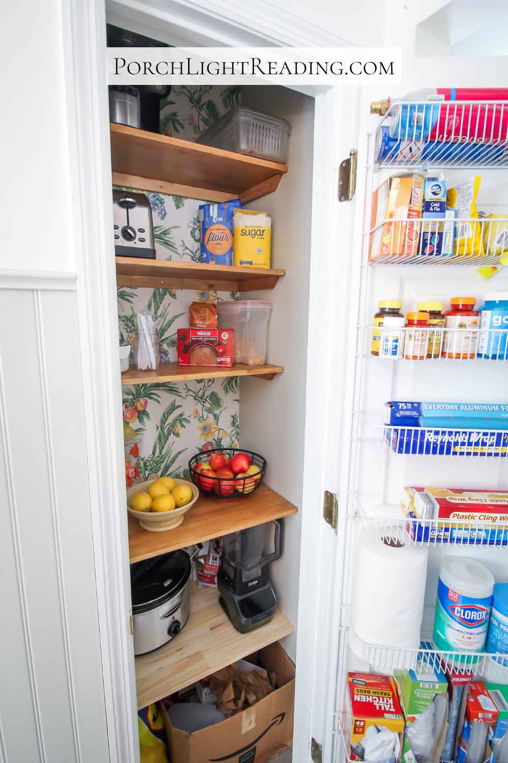Tidy wooden pantry shelves with tropical wallpaper. 