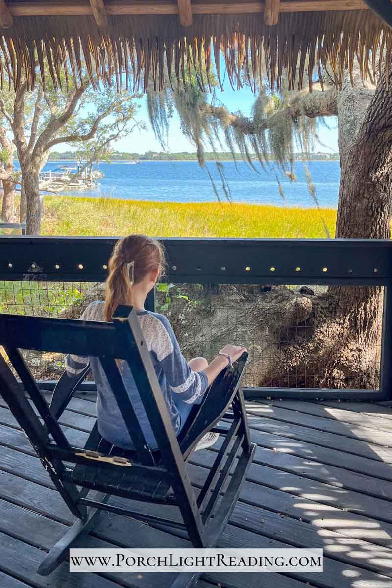 Young girl in a rocking chair looking out over the river. 
