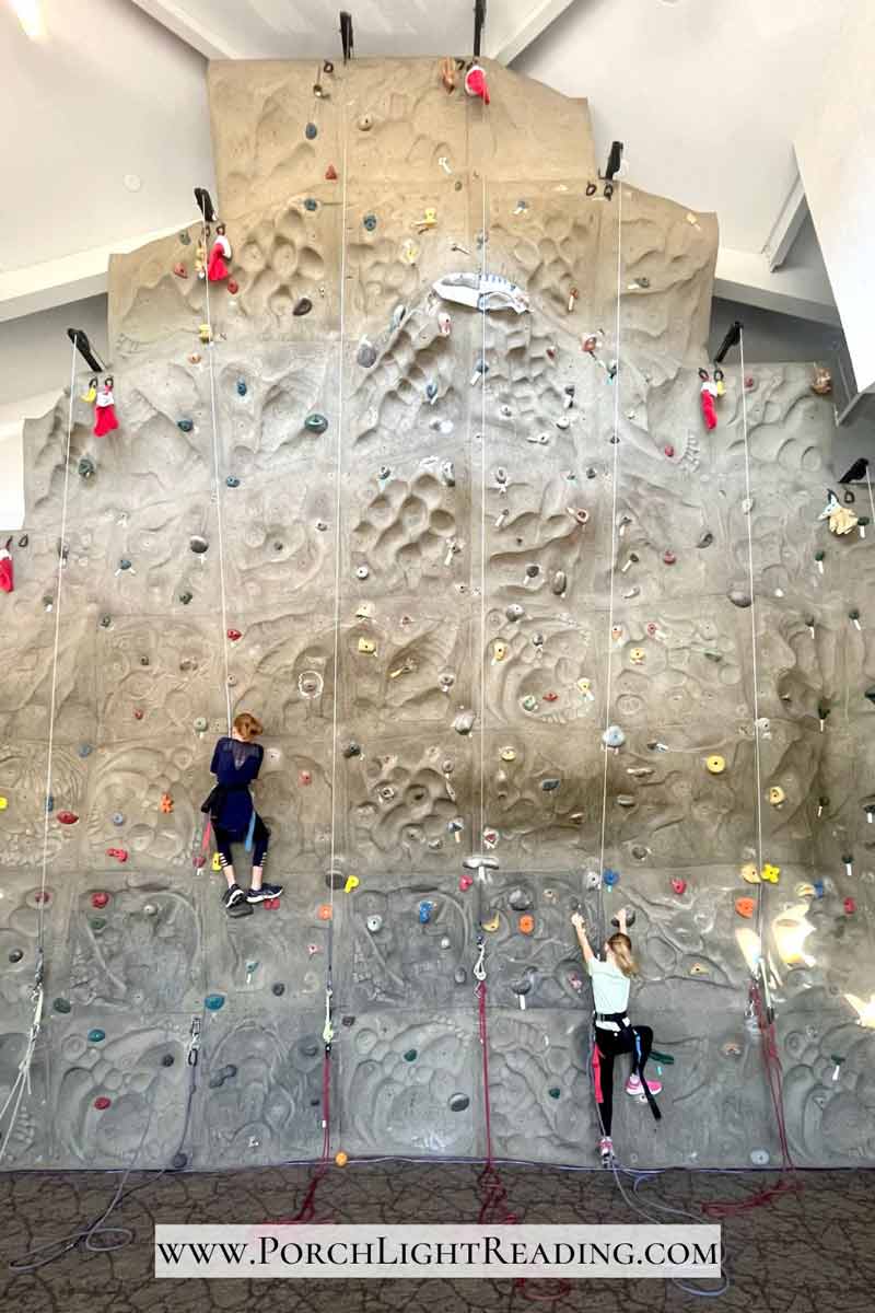 Two kids scaling a rock wall. 