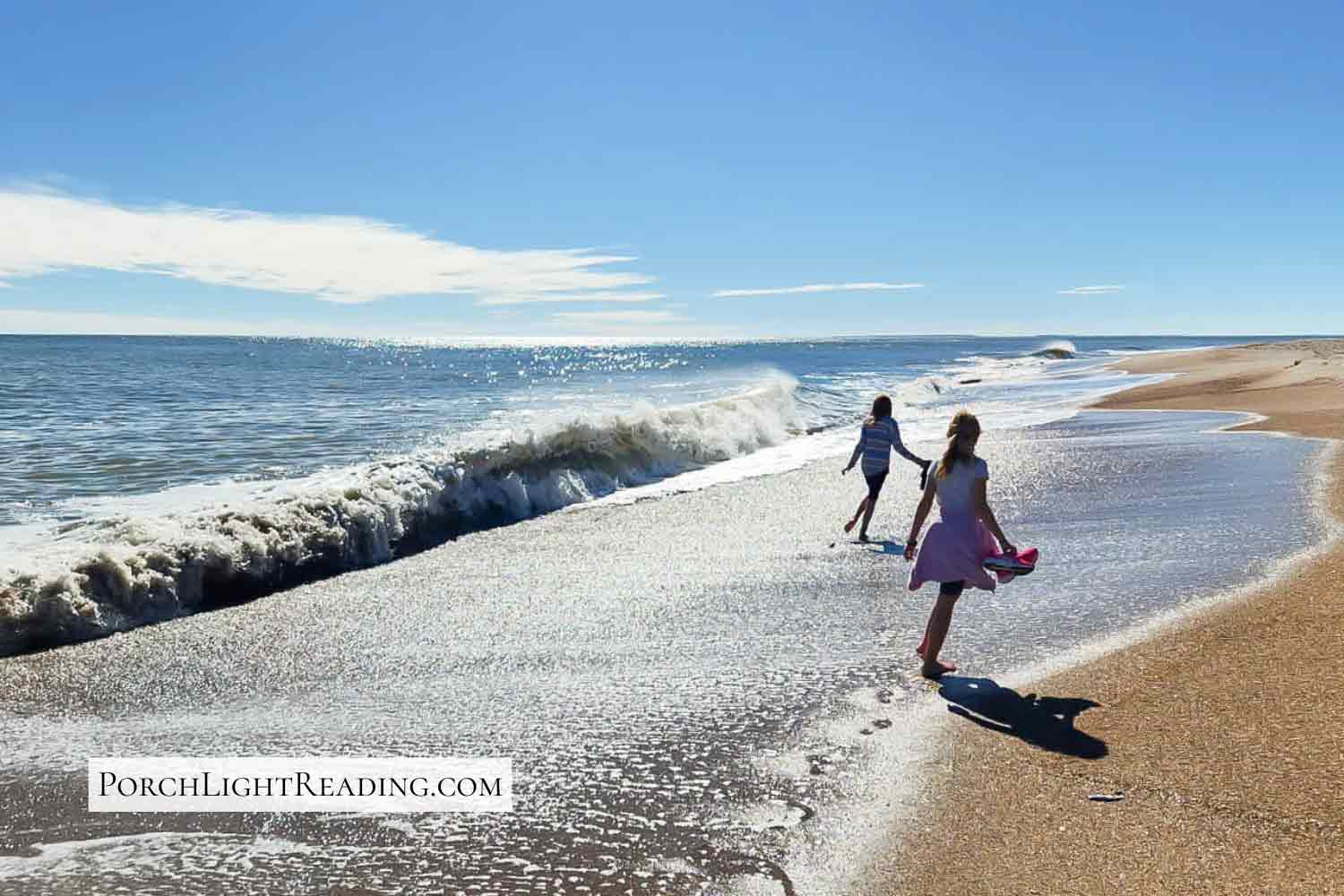 Kids running from the ocean waves. 