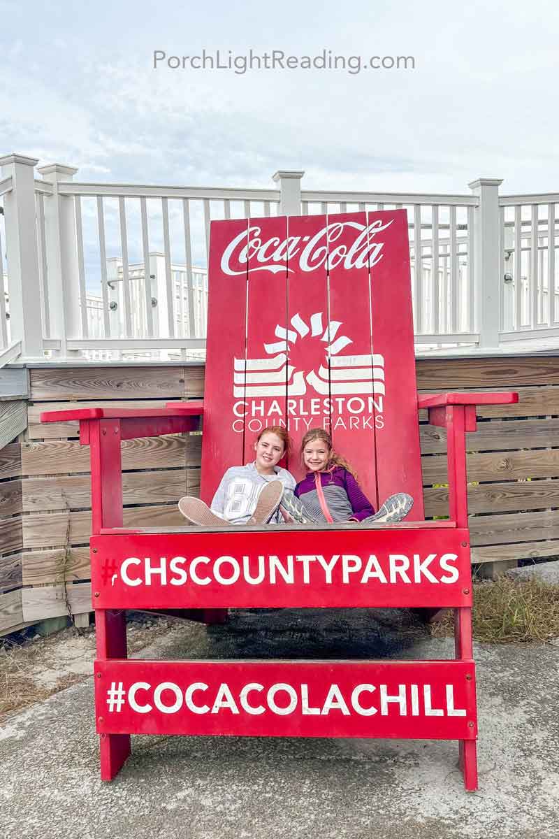 Two kids sitting in the large beach chair at Folly Beach County Park. 