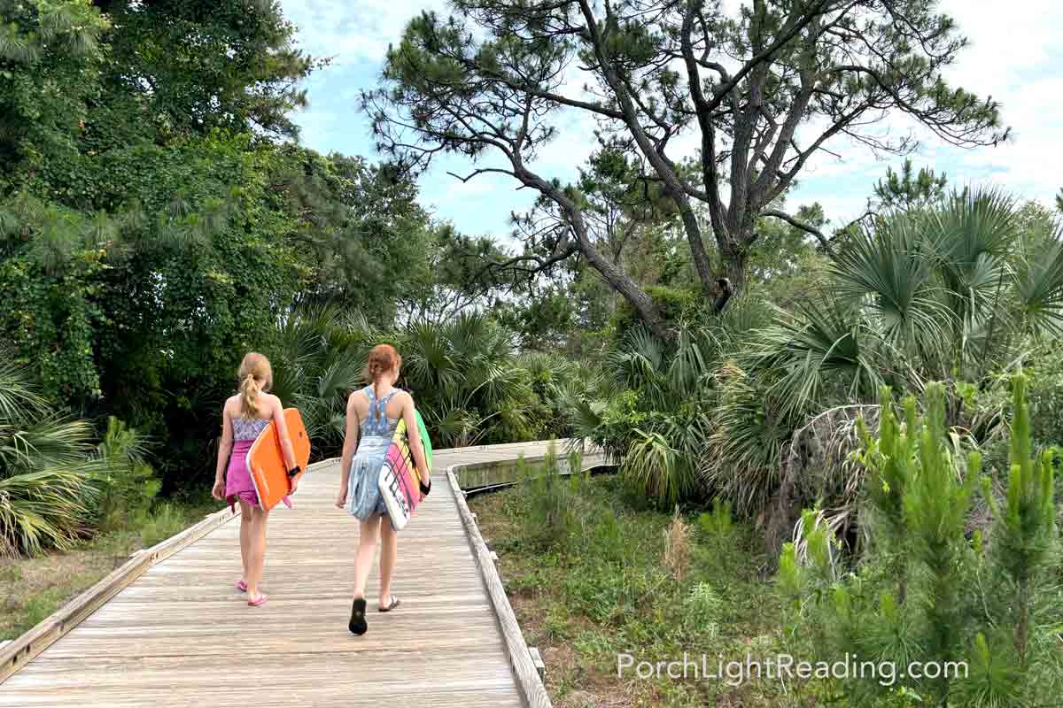 Kids with boogie boards walking down the boardwalk of Kiawah Beachwalker Park. 