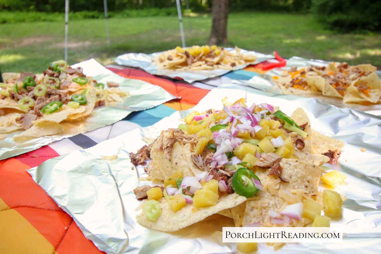 Setting up four plates of individually customized campfire nacho, foil packets. 