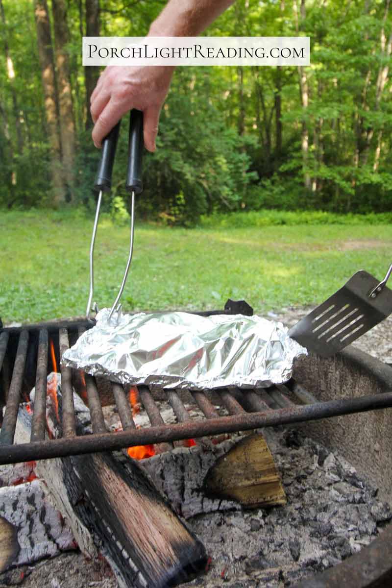 Nacho foil packet cooking over a low campfire. 