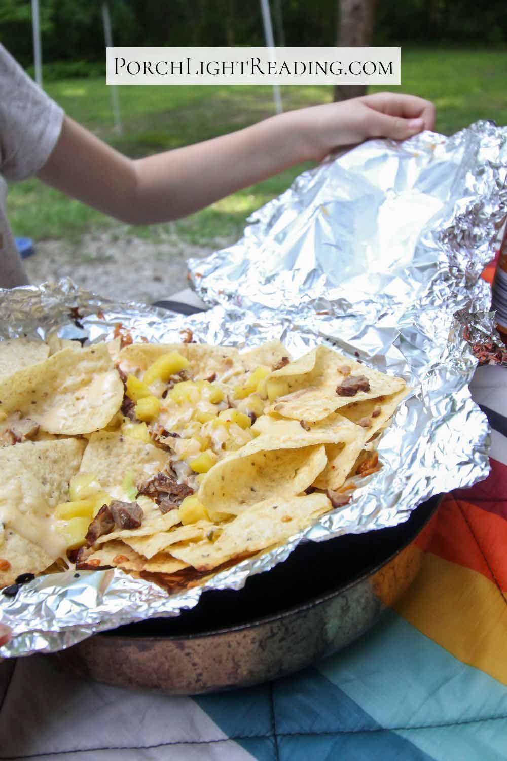 Opening a cooled nacho foil packet to eat for dinner. 