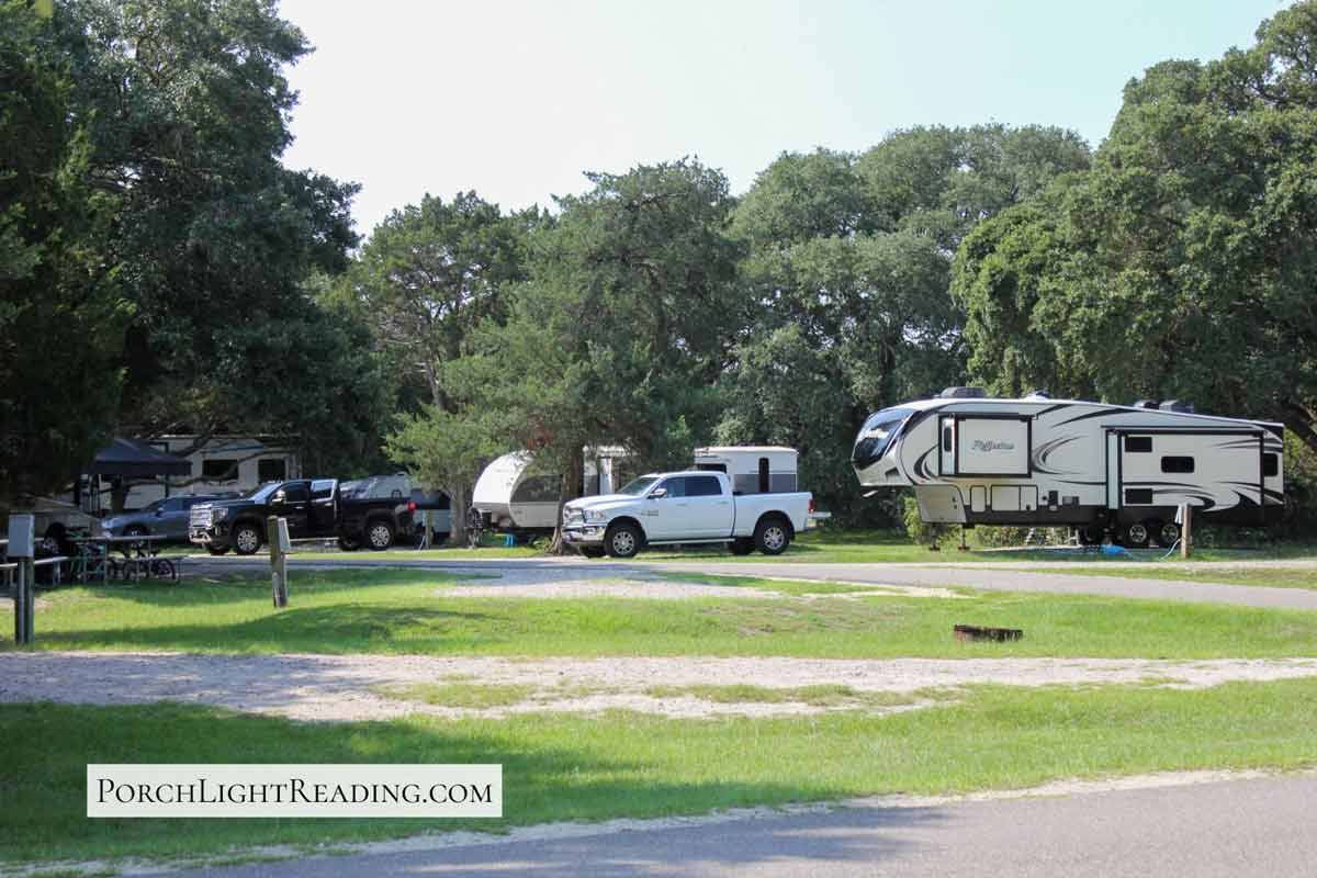 Campground photo with 5th wheel rig and trucks. 