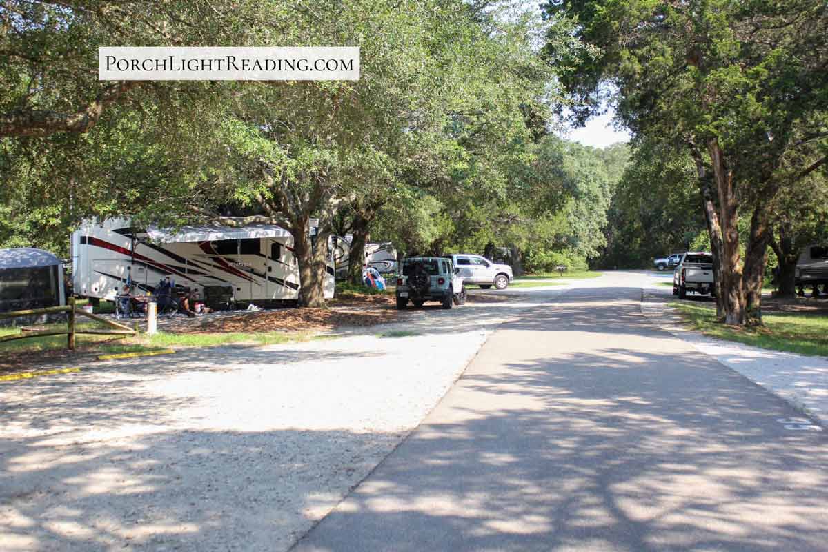 Trees, campers, and vehicles parked along the campground. 