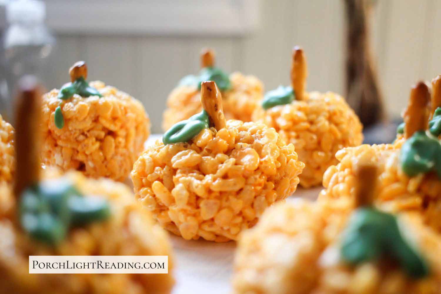 Pumpkin shaped Rice Krispies with a chocolate leaf and pretzel stem.