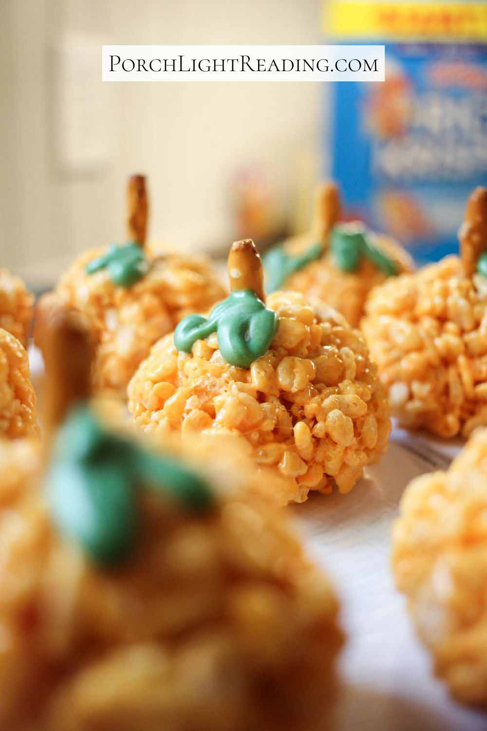 Batch of pumpkin Krispie Treats on parchment paper cooling.