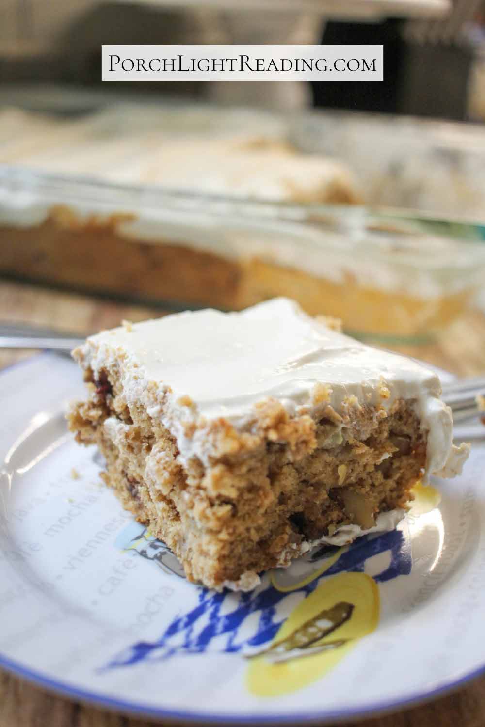 A slice of banana snack cake with nuts and frosting.