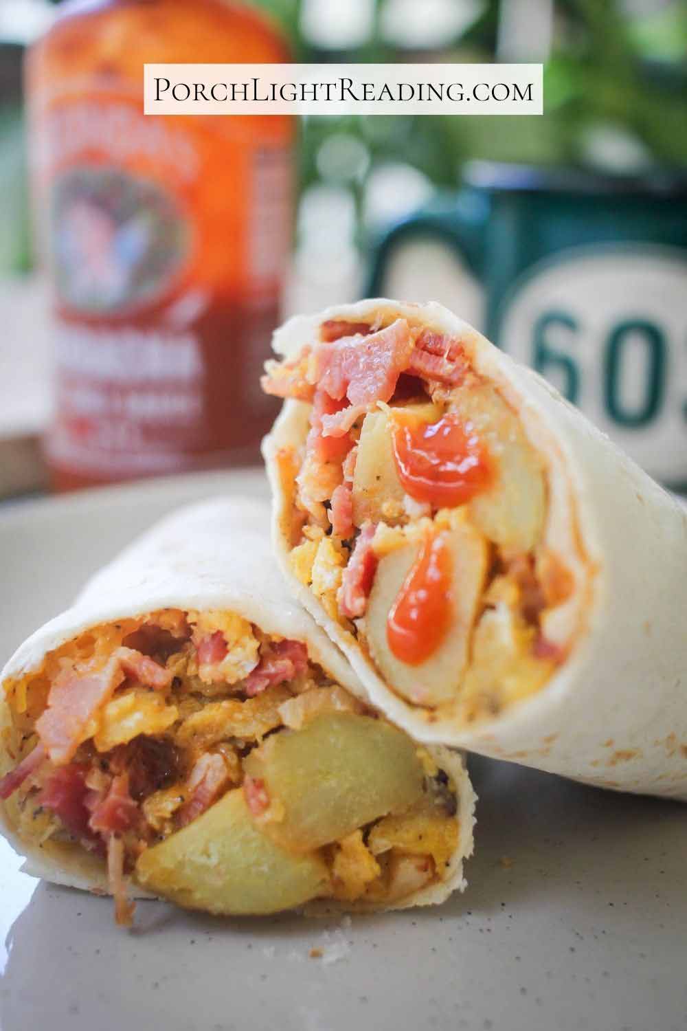 Breakfast burrito filled with bacon, cheese, eggs, potatoes and seasoning and topped with hot sauce.